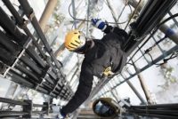 Telecommunication manual high worker engineer repairing 260 feet tall mobile base station (communication tower), high angle of view.