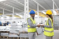 Supervisors handshaking in warehouse