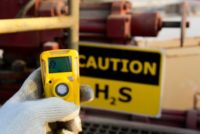 Oilfield technician checking H2S gas with his pocket type H2S Gas detector at well head in oilfield